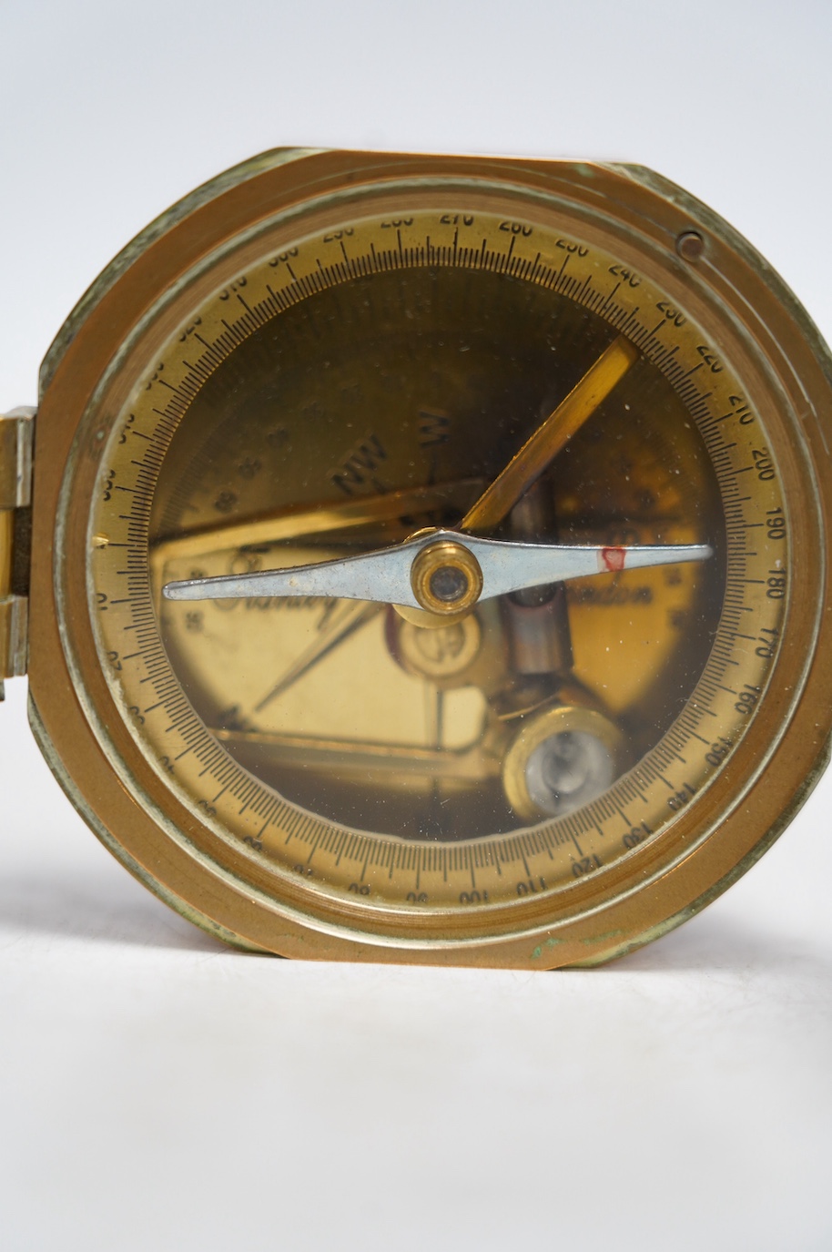 A Stanley brass cased compass with internal spirit level, and a panel with engraved Natural Sine table applied to the lid. Condition - good